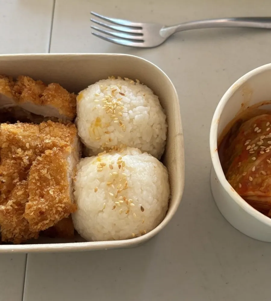 Kotak bento berisi nasi kepal, lauk, telur, dan sayur