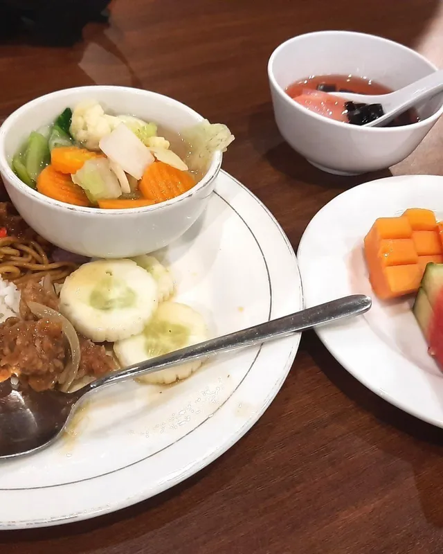 Piring berisi nasi, lauk, dan buah potong