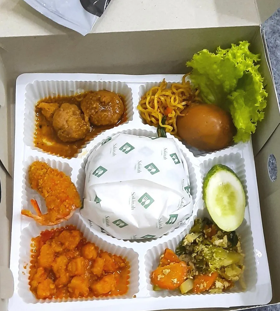 Nasi box bersekat berisi nasi, lauk, sayur, dan sambal